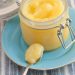 Lemon curd in a jar with a spoonful alongside.