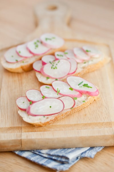 Sliced baguette with radishes on top.