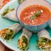 Vegetable summer rolls with a bowl of sauce in the middle.