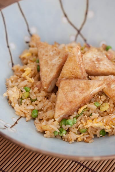 Tofu triangles over fried rice.