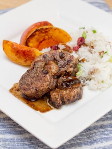 Pork tenderloin medallions with grilled peaches and rice.