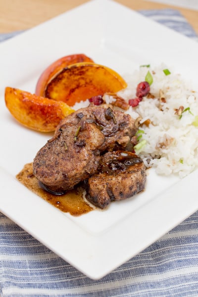 Pork tenderloin medallions with grilled peaches and rice.