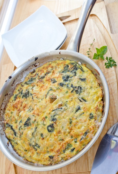 Chard and onion omelet in a frying pan.