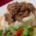 Beef goulash over mashed potatoes with a salad.