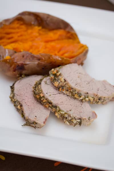 Sliced pork tenderloin with a baked sweet potato.