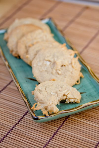 Plate of coconut cookies with a bite taken out of one.