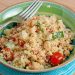 A bowl of couscous with tomatoes and garbanzo beans.