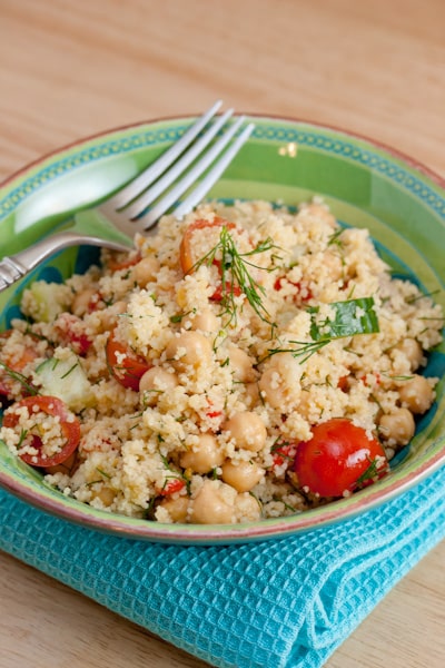 A bowl of couscous with tomatoes and garbanzo beans.