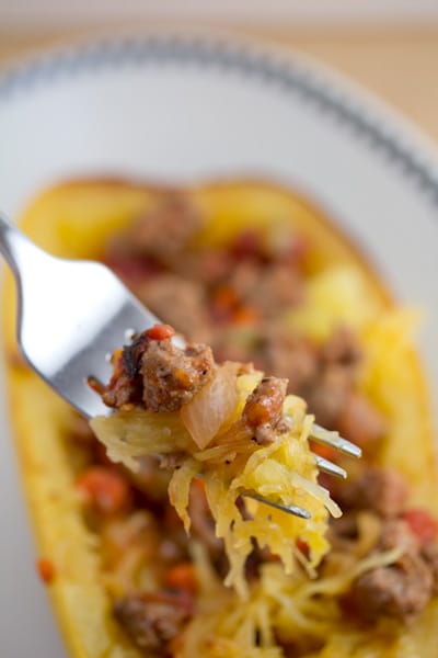 Close-up of a forkful of spaghetti squash with turkey and tomato.