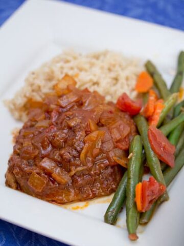 Swiss steak covered with onion sauce served with green beans and rice.