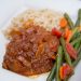 Swiss steak covered with onion sauce served with green beans and rice.
