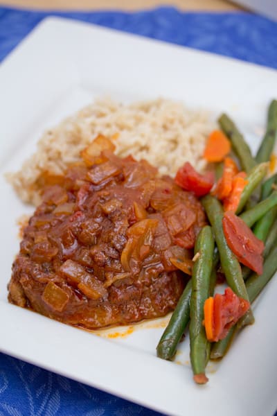 Swiss steak covered with onion sauce served with green beans and rice.