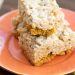 Pumpkin pie rice krispie treats stacked on top of each other on an orange plate.