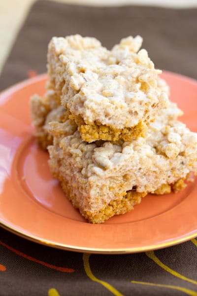 Pumpkin pie rice krispie treats stacked on top of each other on an orange plate.