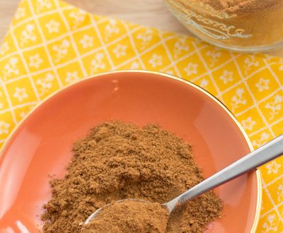 Pumpkin pie spice in a jar and on a plate with a spoon.