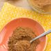 Pumpkin pie spice in a jar and on a plate with a spoon.