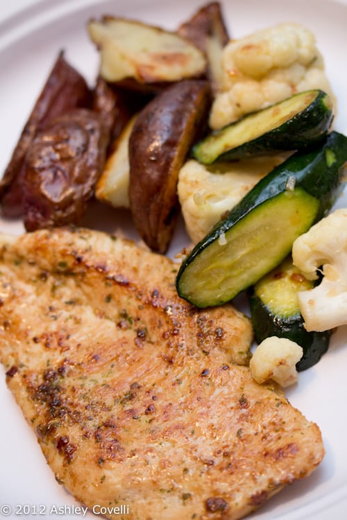 Chicken on a plate with roasted veggies.