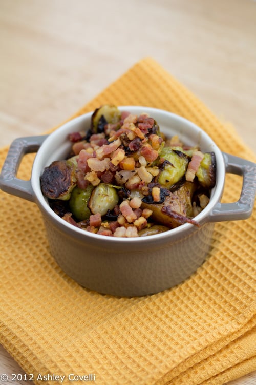 A bowl of roasted Brussels sprouts with pancetta.