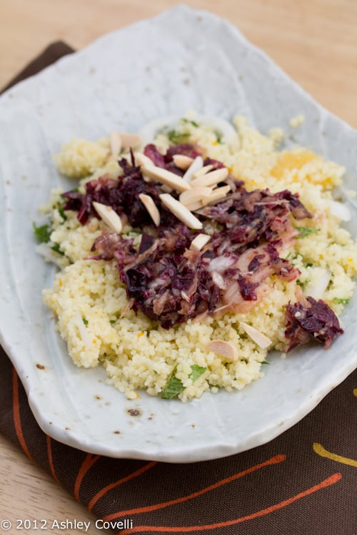 Couscous on a plate topped with slivered almonds.