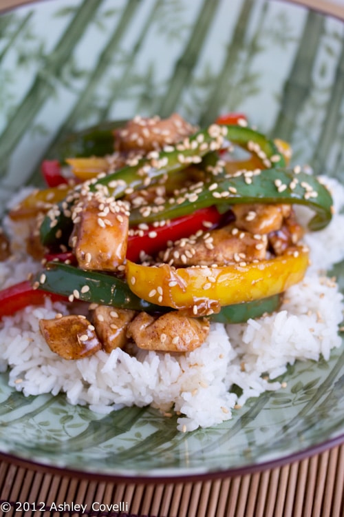 Chicken stir-fry with bell peppers over rice.