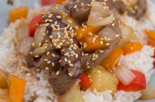 A plate of beef stir-fry over rice.