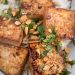 A plate of tofu with peanuts over rice.