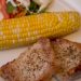A plate of pork chops with corn and salad.