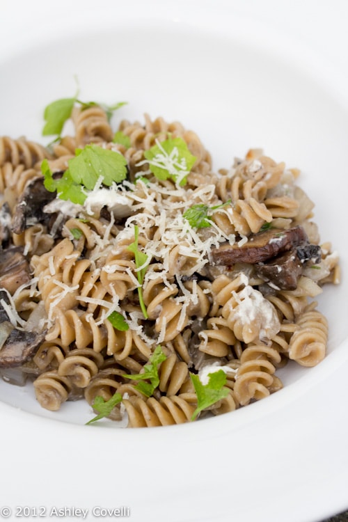 Bowl of rotini pasta with mushrooms and caramelized onions.