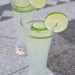 Two glasses of honey limeade garnished with lime wheels.