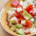 Bowl of tomato, avocado, mozzarella, and onion salad.