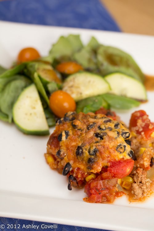 Plate with Mexican quinoa casserole and a salad on the side.