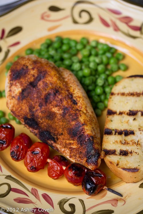 Grilled chicken with tomatoes and peas.