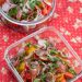 Tomato salad with radishes and herbs in 2 glass containers.