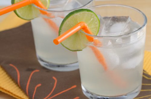 Moscow mules in glasses with orange straws and lime wheels.