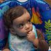 A baby sitting in a high chair.