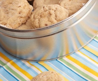 Maple Cookies in a tin with a bite taken out of one.