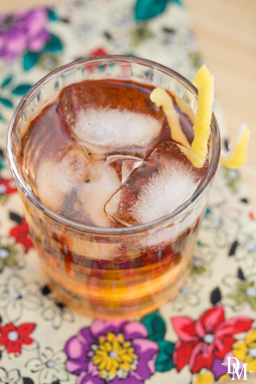 Overhead view of a bourbon cocktail garnished with a lemon twist.