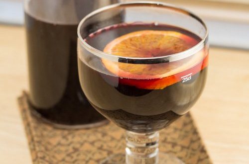 Goblet of mulled wine with a bottle behind.