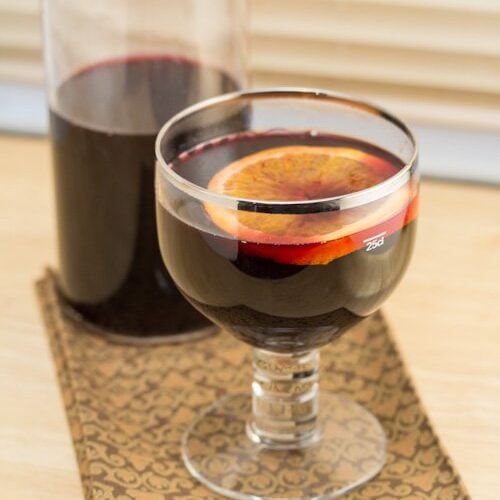 Goblet of mulled wine with a bottle behind.