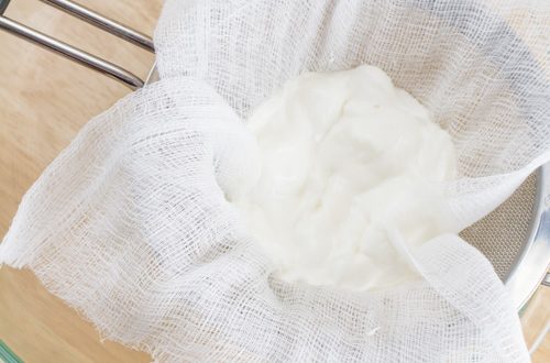Straining yogurt with cheesecloth to make Greek yogurt.