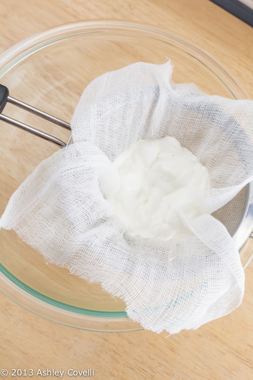 Straining yogurt with cheesecloth to make Greek yogurt.