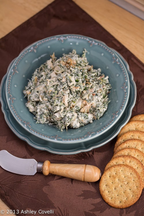 Caramelized Onion and Spinach Dip with Sage in a bowl with crackers.