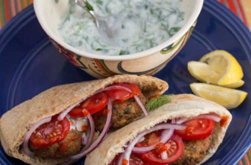 Falafel in pita bread with toppings served with yogurt-herb sauce.