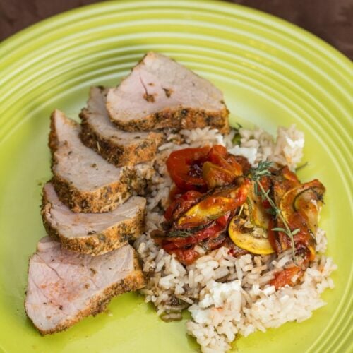 Plate of herb rubbed roast pork tenderloin with ratatouille and rice.