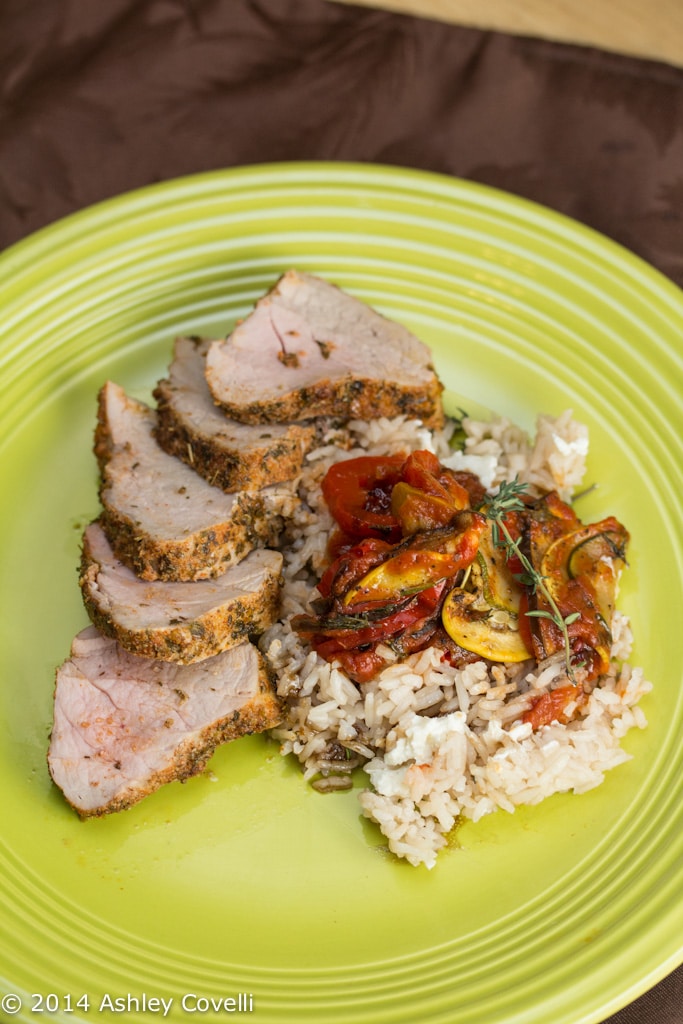 Plate of herb rubbed roast pork tenderloin with ratatouille and rice.