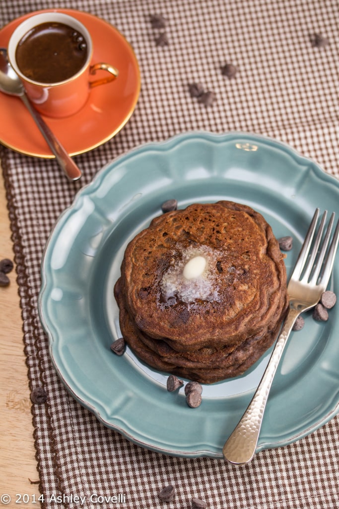 Mocha chip pancakes on a plate with a cup of espresso served alongside.