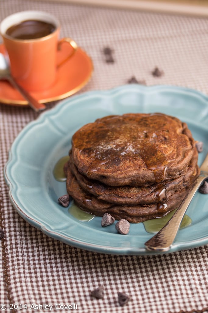 Mocha chip pancakes on a plate with a cup of espresso served alongside.