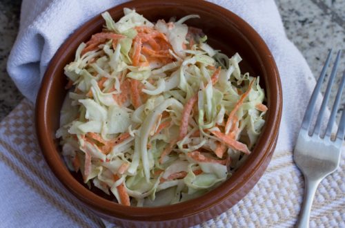 Overhead view of a bowl of coleslaw with a fork.