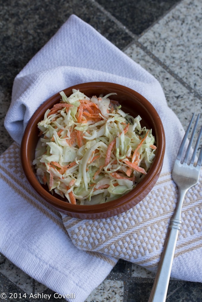 Overhead view of a bowl of coleslaw with a fork.