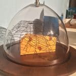 Dome with fake cheese covered with a spiderweb underneath.